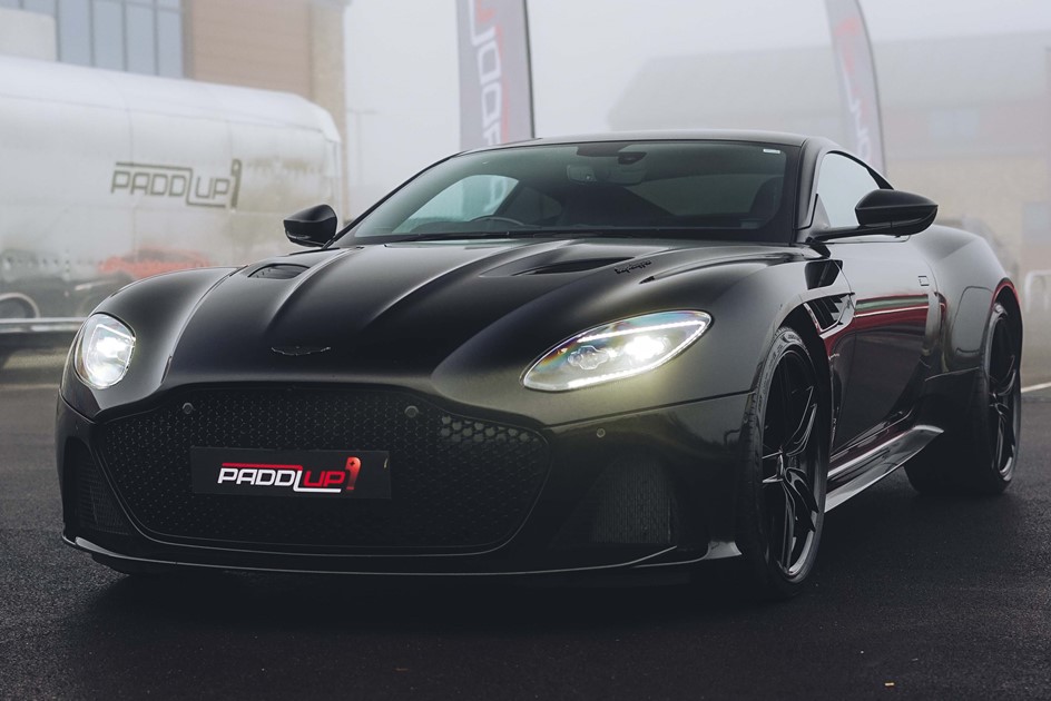 An Aston Martin DBS Superleggera in front of The PaddlUp Rooms