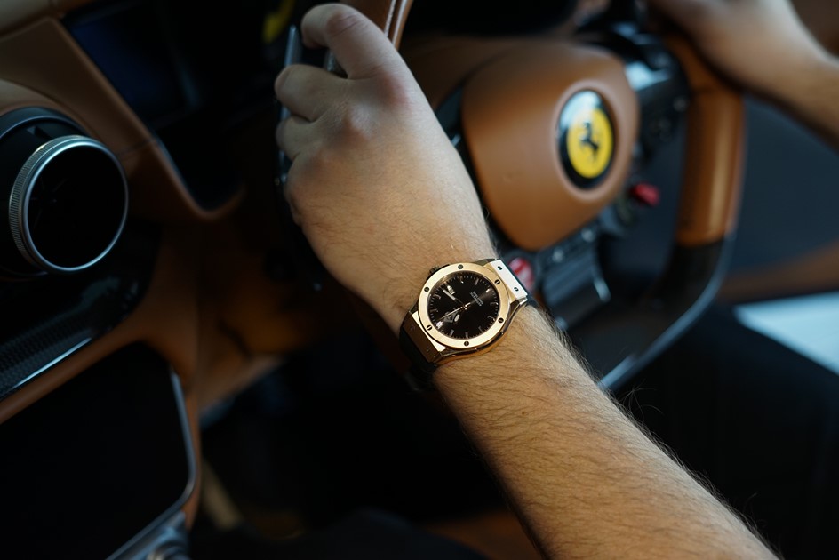 A designer Tesouro Aspire watch with a Ferrari steering wheel backdrop