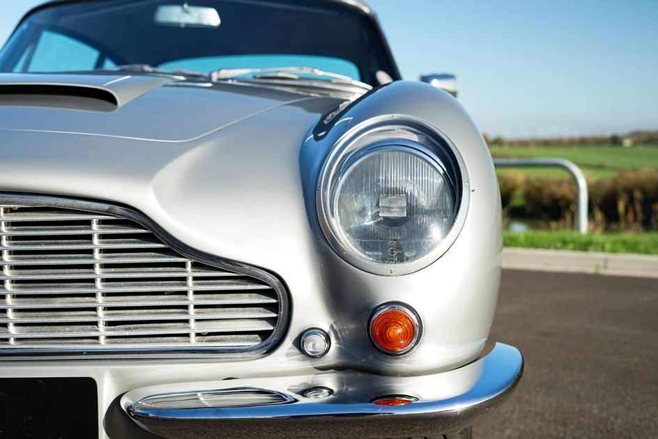 The headlight and grille of an Aston Martin DB6 with extensive maintenance and racing records