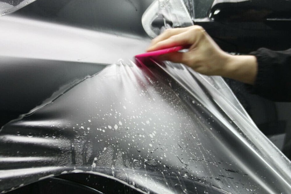 Paint protection film being applied to a supercar